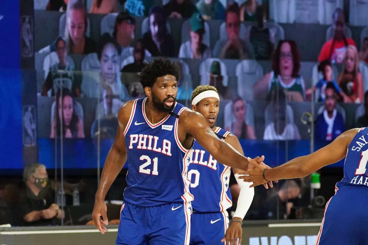 Joel Embiid #21 of the Philadelphia 76ers high-fives his teammates during a game against the Boston Celtics during Round One, Game Three of the NBA Playoffs on August 23, 2020 at the The Field House at ESPN Wide World Of Sports Complex in Orlando, Florida.