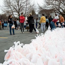 Eva Noriega and Jorge Garcia collect donations from Utah Food Bank at the parking lot of a chapel belonging to The Church of Jesus Christ of Latter-day Saints in Taylorsville on Monday, March 16, 2020. Hundreds of people waited in line to receive the donations.