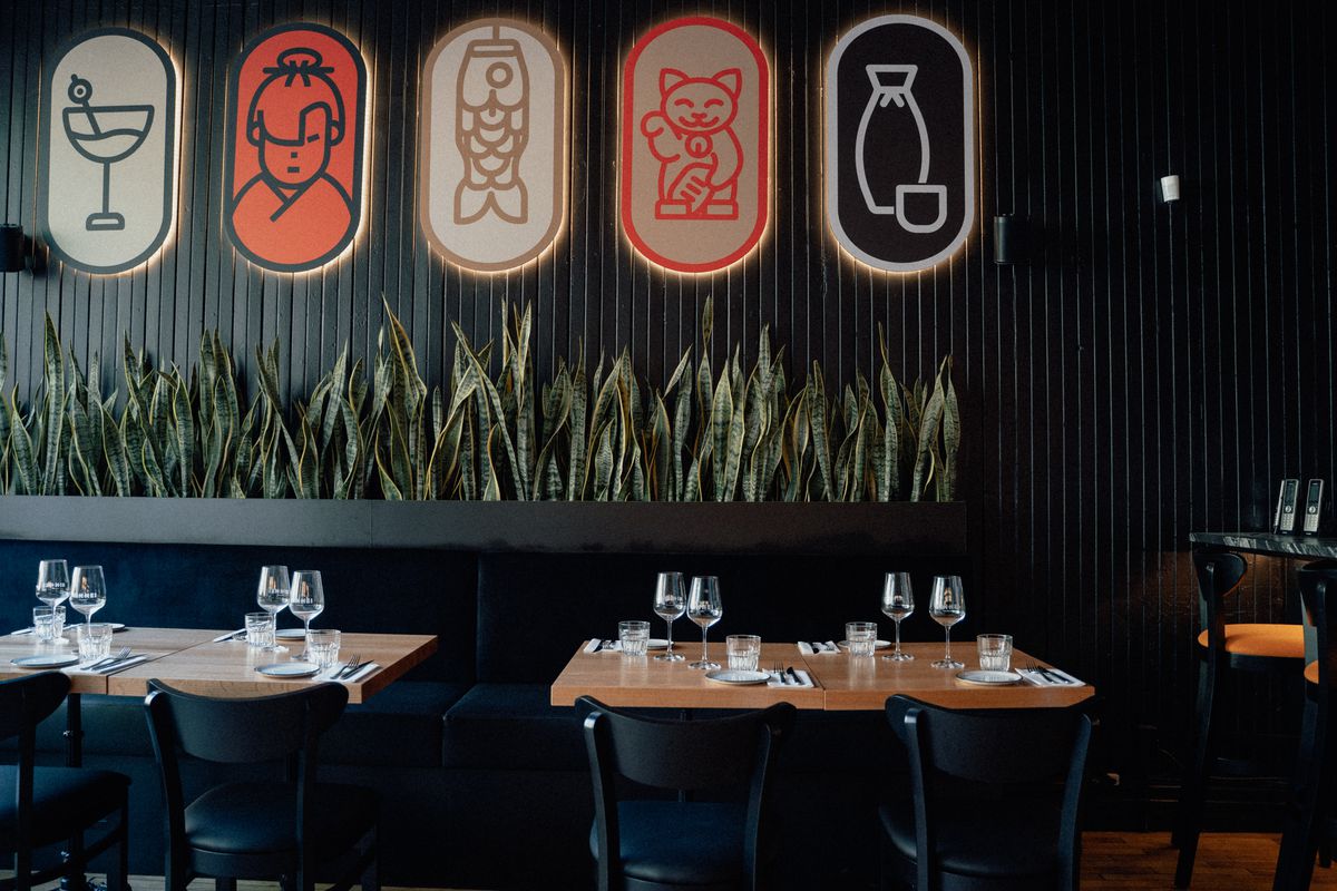 inside restaurant dining room with black and wood furniture and graphics on walls
