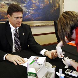 Rep. Jim Dunnigan of Taylorsville has a blood sample taken by Johnna Harris of Davis Hospital as part of an American Heart Association-sponsored health screening at the state Capitol on Friday. 