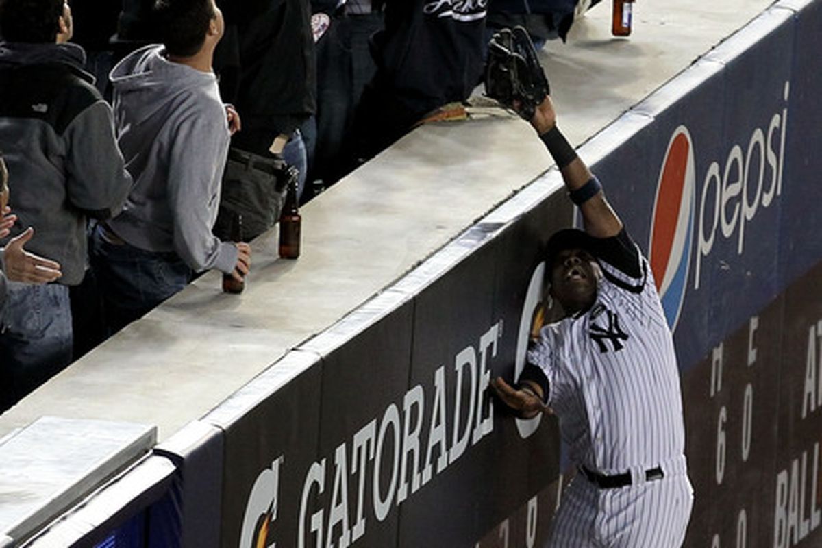 Marcus Thames of the Yankees goes up to make a play on a ball hit by Josh Hamilton of the Rangers in Game Four of the ALCS during the 2010 MLB Playoffs at Yankee Stadium on October 19 2010. Home run? Or not? (Photo by Al Bello/Getty Images)