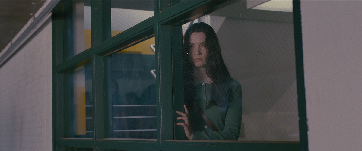 Mia Wasikowska looks out a window in Stoker