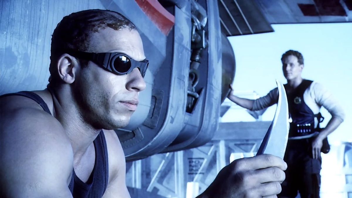 (LR) Richard B. Riddick (Vin Diesel) mirando un cuchillo con William J. Johns (Cole Hauser) al fondo en Pitch Black.