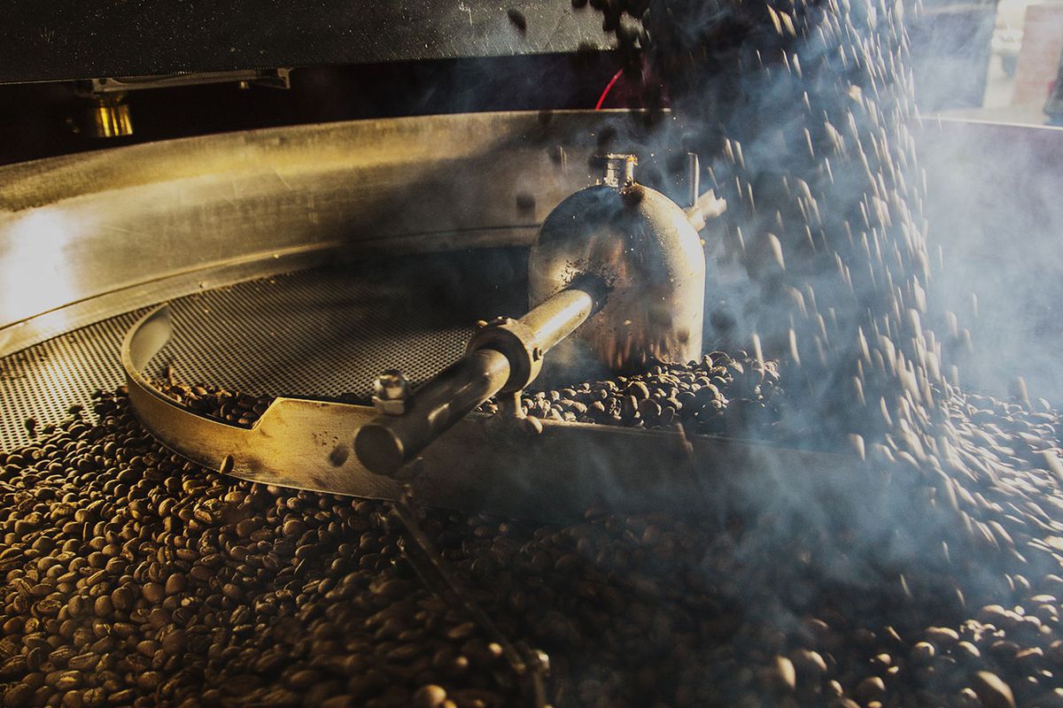 Coffee beans falling into a roaster at Caffè Kenon