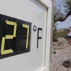 A visitor to the Furnace Creek Vistitor Center walks by a digital thermometer in Death Vally National Park Friday, June 28, 2013 in Furnace Creek, Calif. Excessive heat warnings will continue for much of the Desert Southwest as building high pressure triggers major warming in eastern California, Nevada, and Arizona. (AP Photo/Chris Carlson)