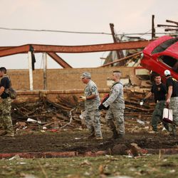 Workers walk past the rubble of Plaza Towers Elementary School after a tornado moved through Moore, Okla., Monday, May 20, 2013. 