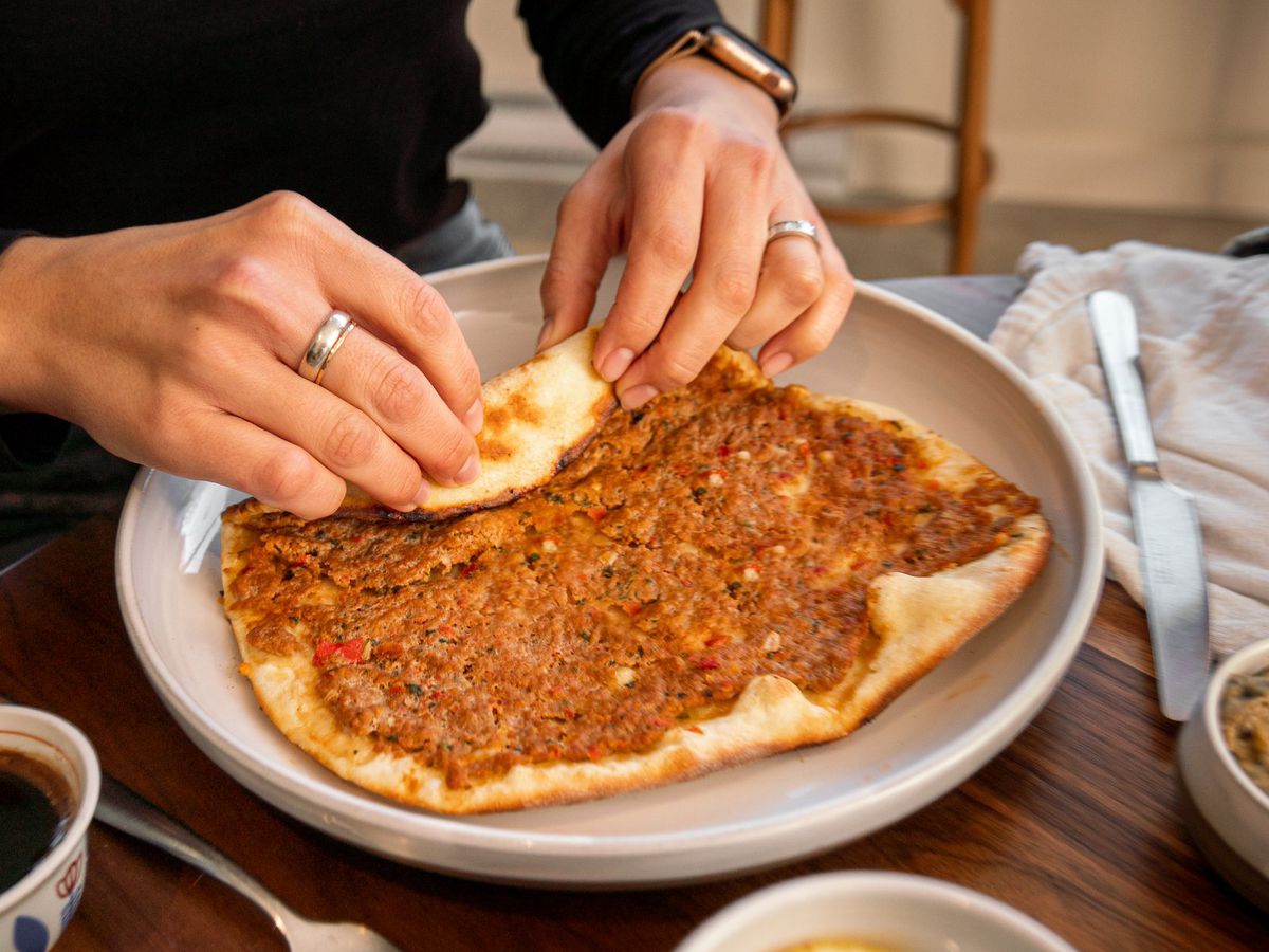 person rolled red-coloured beef flatbread