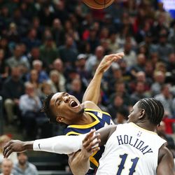 Utah Jazz guard Donovan Mitchell (45) is fouled by New Orleans Pelicans guard Jrue Holiday (11) as Utah Jazz and the New Orleans Pelicans play an NBA basketball game at Vivint Arena in Salt Lake City on Wednesday, Jan. 3, 2018.