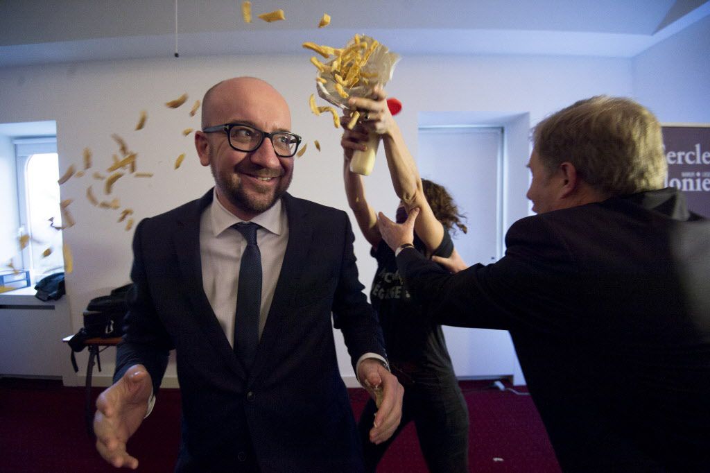 Pierre Rion (right) tries to intervene as activists throw fries and mayonnaise on Belgian Prime Minister Charles Michel. | Getty Images