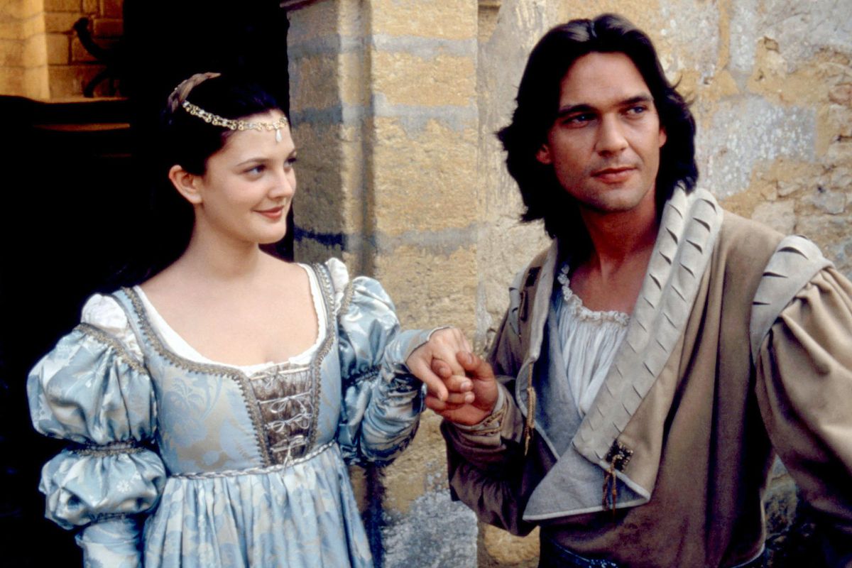 Drew Barrymore as Cinderella holds Dougray Scott’s hand while wearing a fancy dress in Ever After