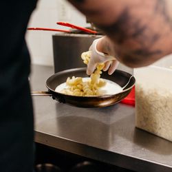 Sanches adds noodles to the cheese sauce.