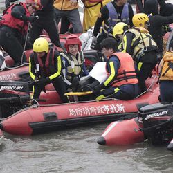 Emergency personnel remove the body of a passenger of a commercial plane after it crashed in the water in Taipei, Taiwan Wednesday, Feb. 4, 2015. The Taiwanese commercial flight with 58 people aboard clipped a bridge shortly after takeoff and crashed into the river in the island's capital on Wednesday morning. 