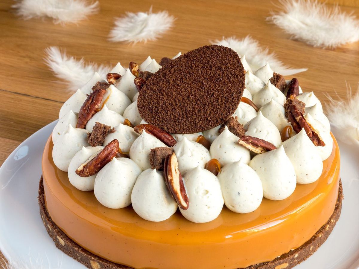 A cake topped with little meringues and a large chocolate garnish
