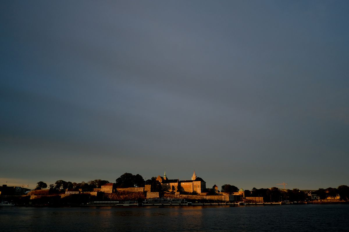 Akershus Fortress, dating to the late 13th century, is seen at sunset in Oslo, Norway on Sunday, Aug. 12, 2018. The site serves as a popular tourist attraction, while the catacombs beneath it have been converted into a parking garage and charging station 