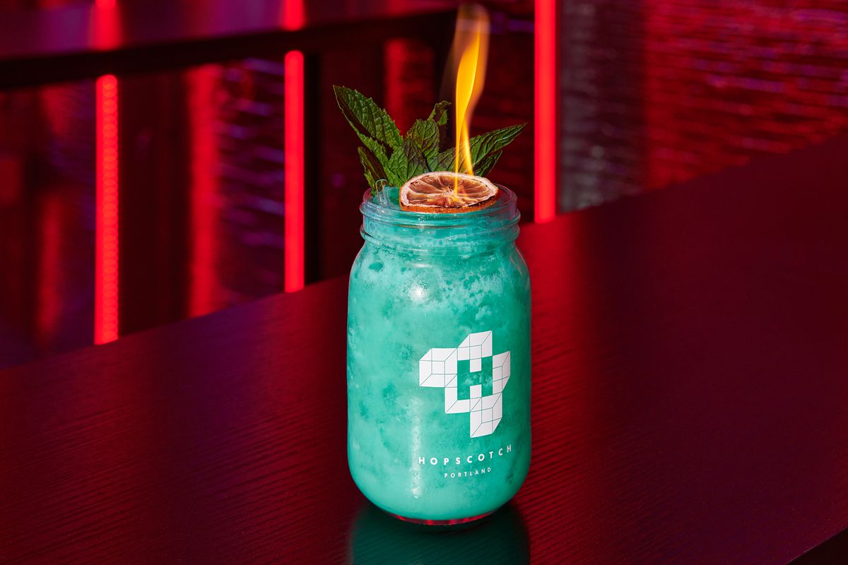 A tiki-esque cocktail garnished with a lime lit on fire at Hopscotch.