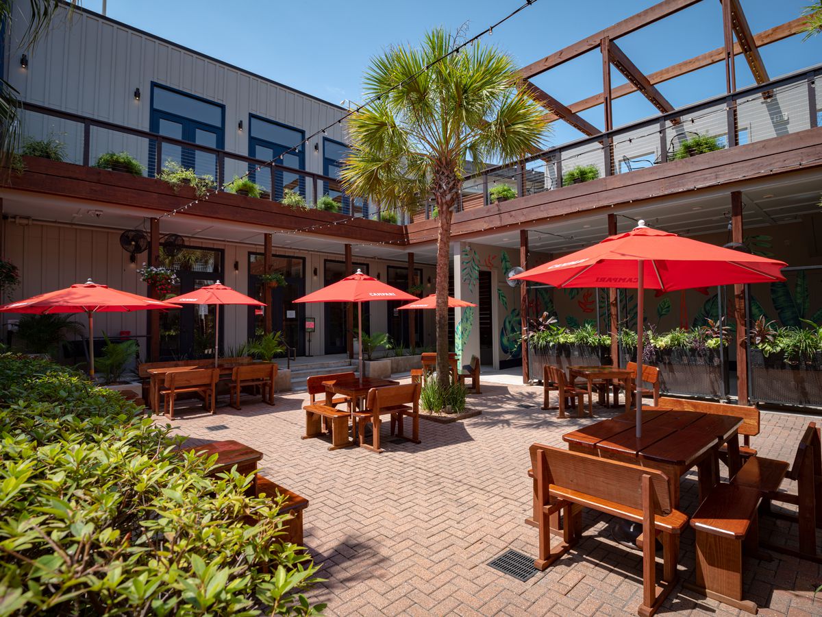An outdoor seating space with tables and umbrellas