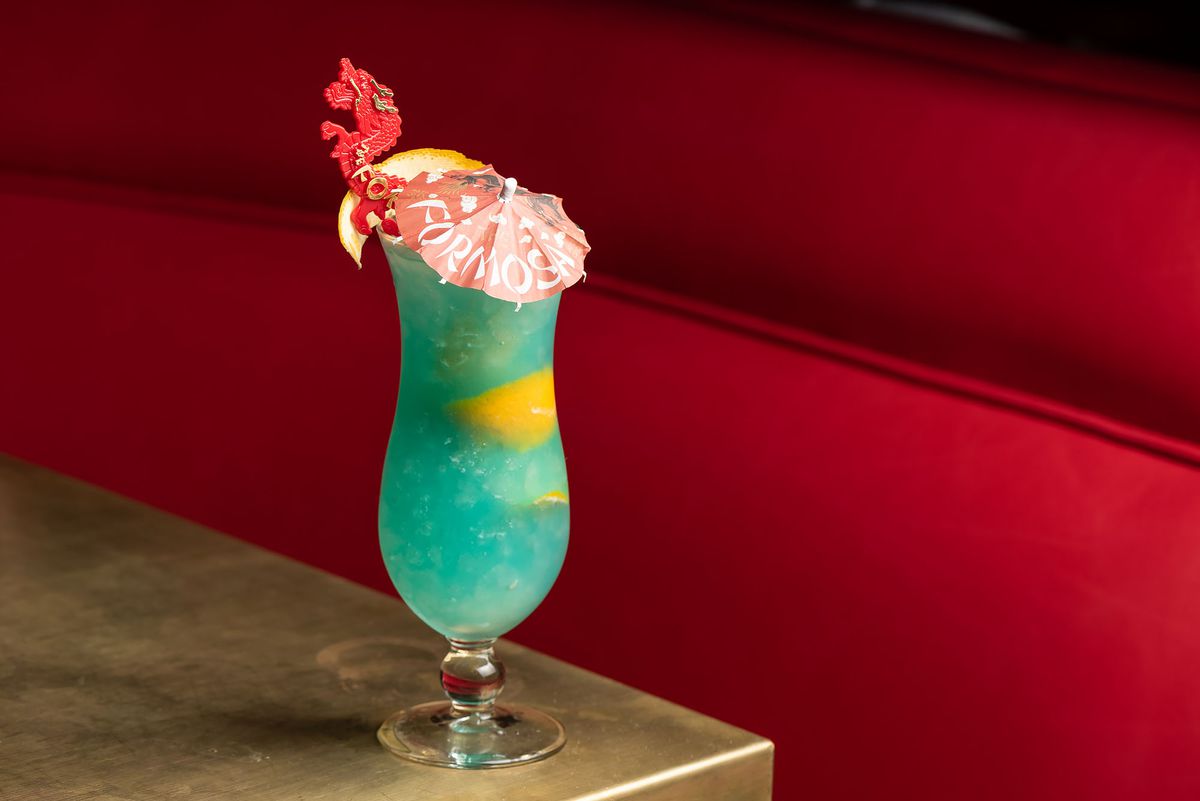 Windex blue cocktail with an umbrella and curvy cup.