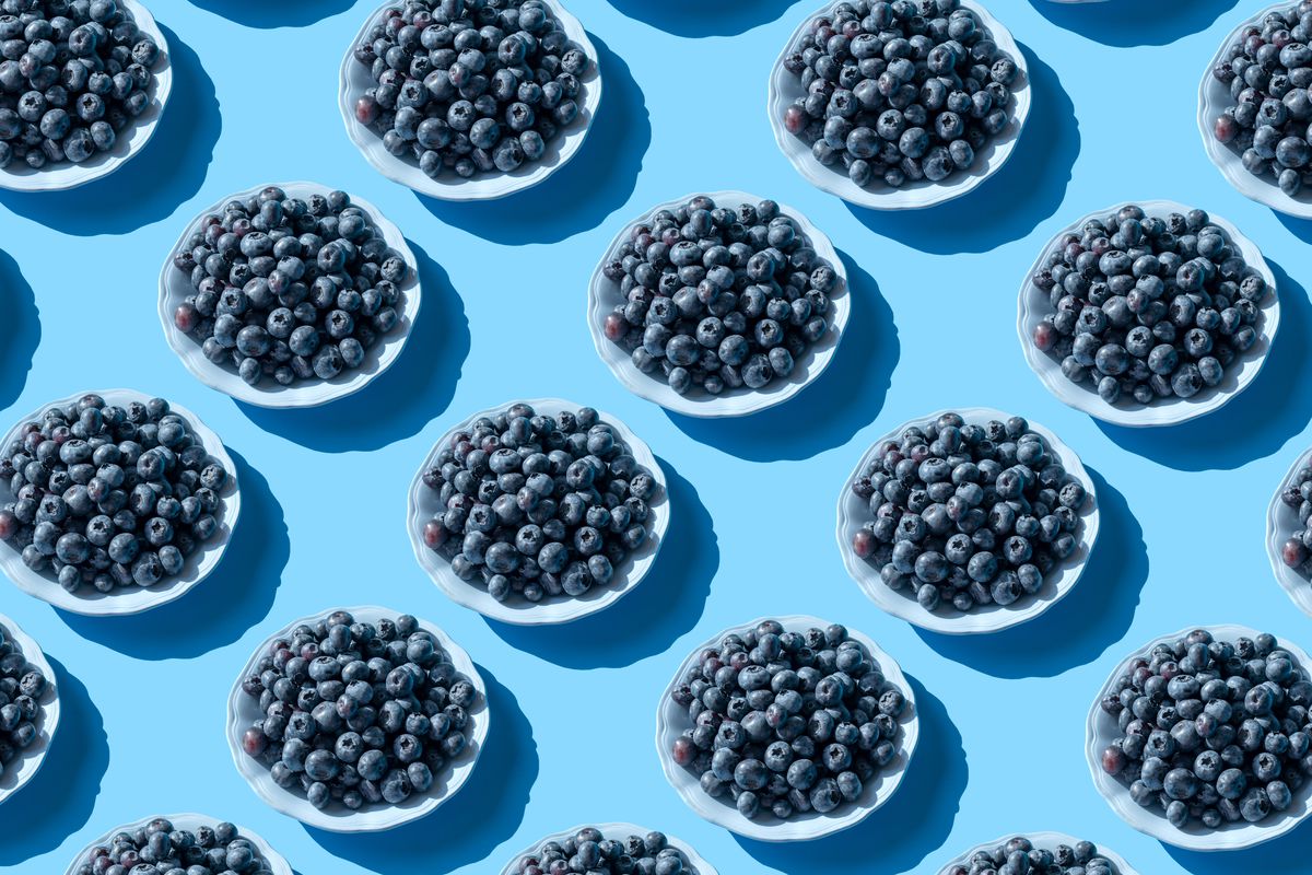 Blueberries on plates on a blue background. 