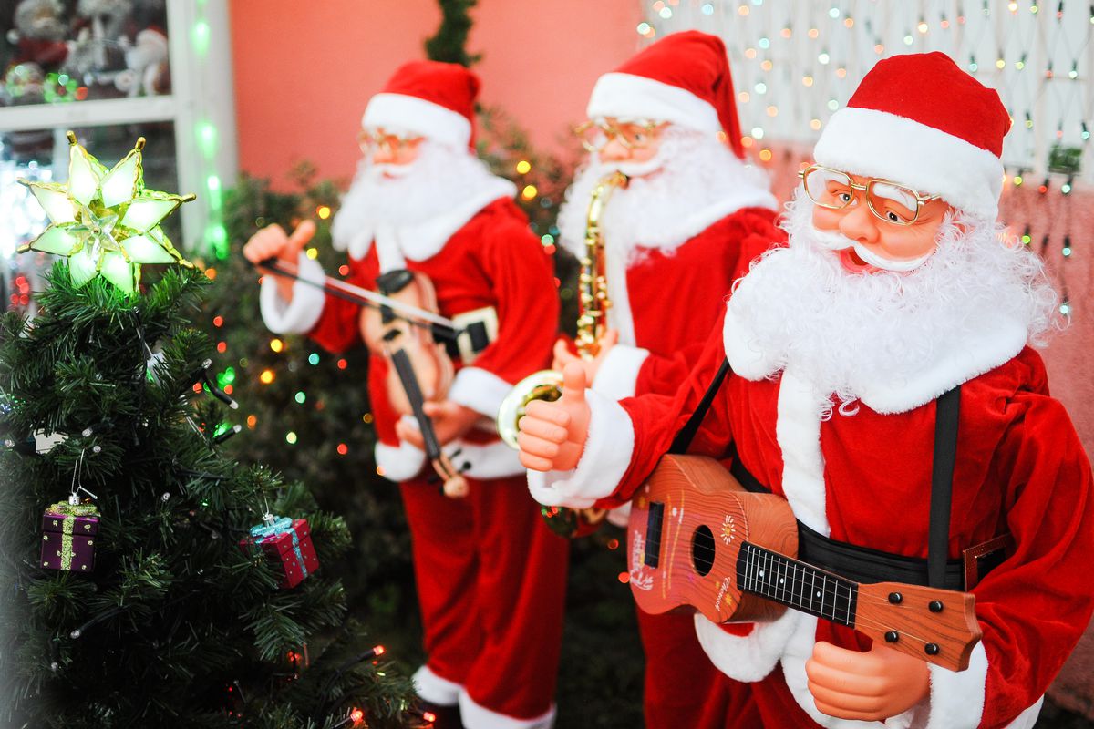 Cute Santa statues with instruments in a row.