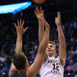 Brigham Young Cougars forward Eric Mika (12) pushes up a shot over Brigham Young - Hawaii forward/center Jeff Given (31) as BYU and BYU-Hawaii play in preseason action at the Marriott Center in Provo on Wednesday, Nov. 9, 2016.