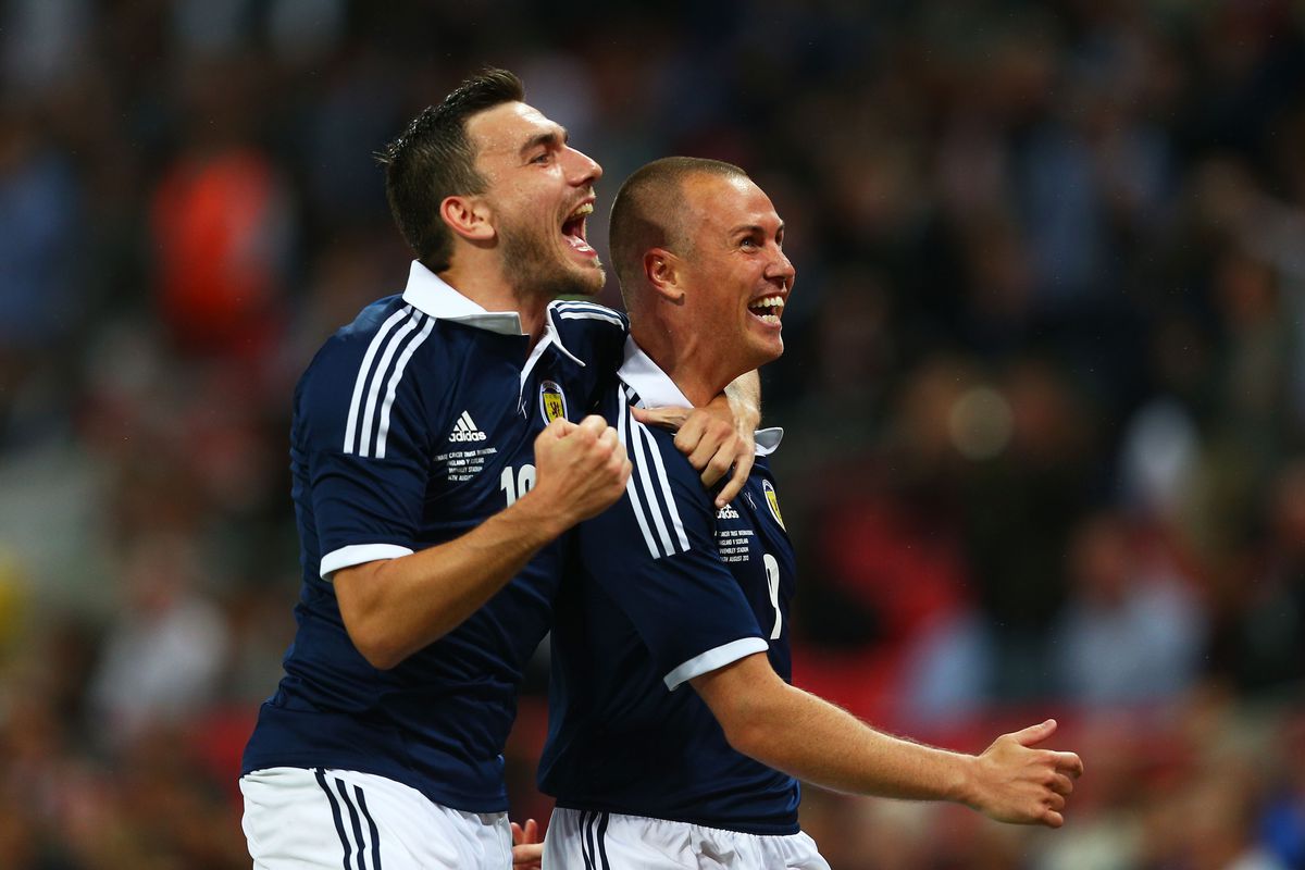 Kenny Miller (R) celebrates his 49th minute goal against England with Norwich City's Robert Snodgrass