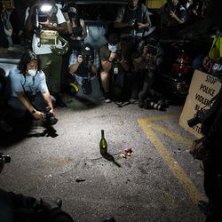 Mourners and protesters places flowers and other momentos near a blood stain at the corner of 63rd Street and Sheridan Road, where a person was shot by an alleged vigilante on the fourth day of civil unrest after police shot Jacob Blake, Wednesday night, Aug. 26, 2020. Two people were killed and one person was shot and wounded during unrest Tuesday night and Kyle Rittenhouse, 17, has been charged in connection with the shootings.