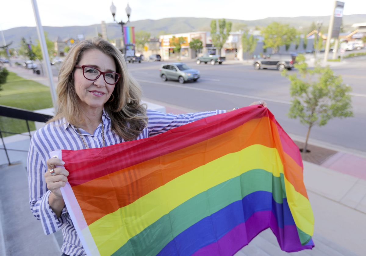 Heber City Mayor Kelleen Potter poses for a portrait in front of pride flags hanging on Main Street in Heber City on Monday, June 10, 2019.