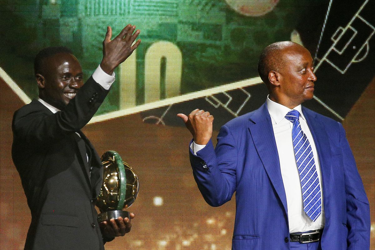Sadio Mané waves to the crowd as he holds his new Men’s Player of the Year trophy, standing next to CAF President Patrice Motsepe