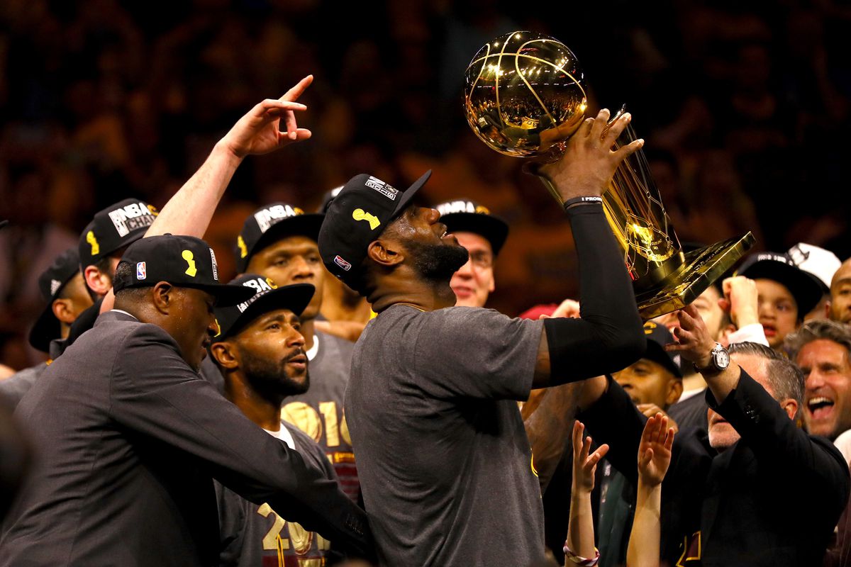 LeBron James and his teammates stand in awe of the Larry O'Brien trophy as they capture the first professional sports championship in Cleveland for 64 years. 