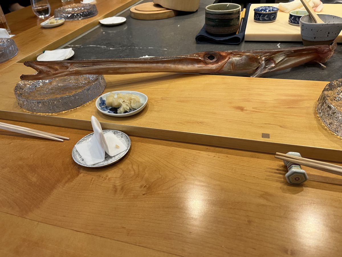 The long head of a cornet fish on a sushi counter.
