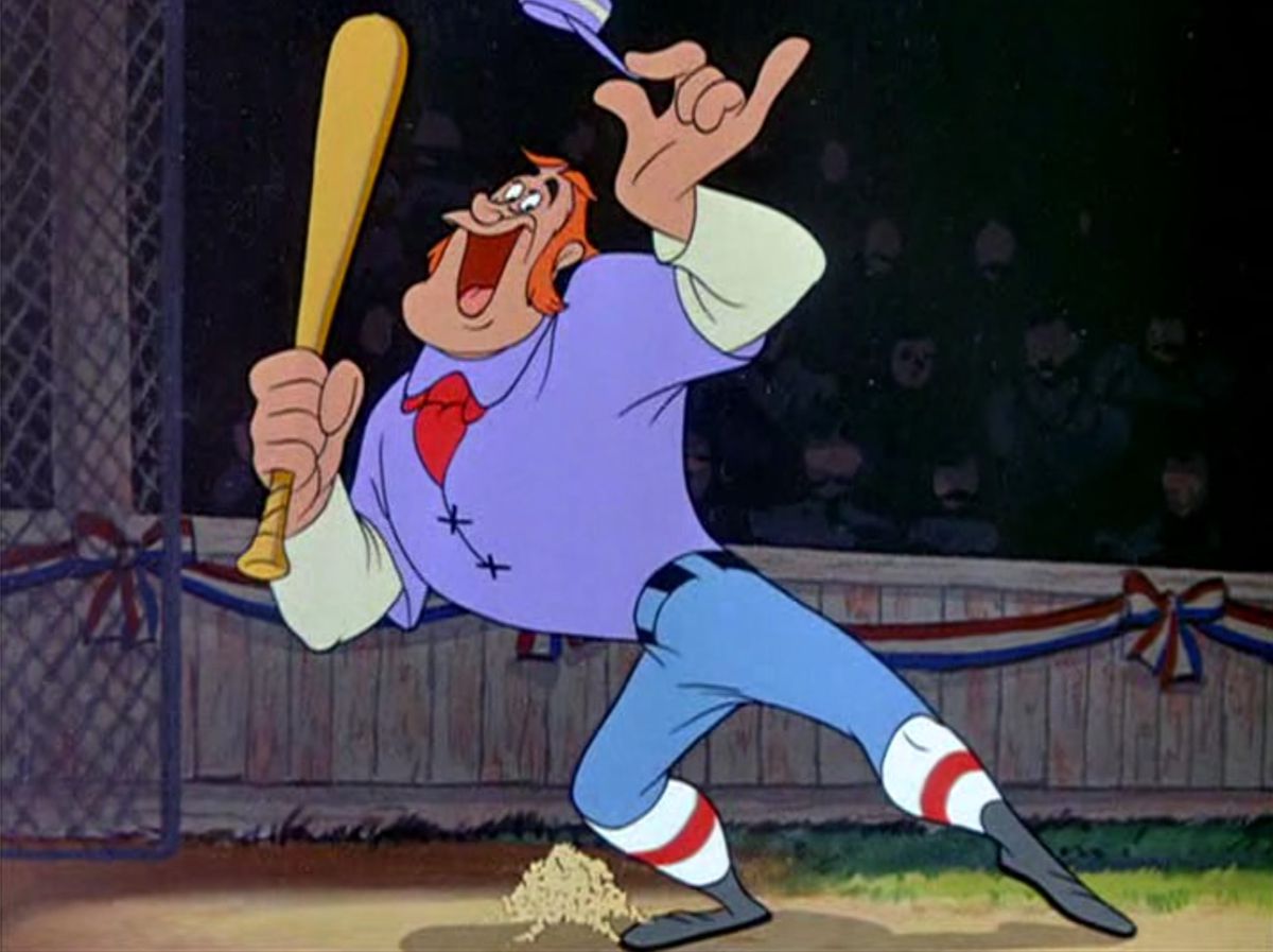 Casey, a deep-chested, goofy-faced man in a purple shirt, stands at home plate on a baseball diamond, tipping his hat to the audience and holding up his bat in the Disney short “Casey at the Bat”
