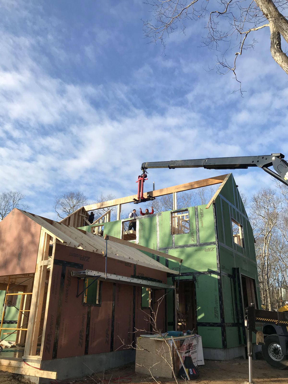 Image of boom truck lowering main ridge beam into position at TOH 2020 Idea House on the Cape