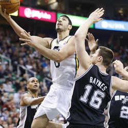 Utah Jazz's center Enes Kanter (0) drives to the hoop on Spurs' Aron Baynes as the Utah Jazz and the San Antonio Spurs play Saturday, Dec. 14, 2013 at EnergySolutions Arena in Salt Lake City. The Spurs won 100-84.