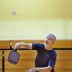 In a Wednesday, Jan. 14, 2015 photo, Ken Criss returns a shot during a pickleball game at Cuba Hunter Recreation Center in Jacksonville, Fla. Pickleball is described as a combination of tennis, badminton and pingpong. The game is played with a solid paddle and a plastic, perforated ball resembling a Wiffle ball. Because pickleball is low-impact but gets the heart rate going, it"™s becoming especially popular with the 50-and-up crowd.