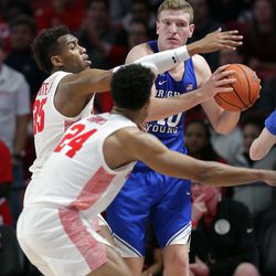 BYU forward Kolby Lee (40) looks to pass the ball under pressure from Houston forward Fabian White Jr. (35) and guard Quentin Grimes (24) during the first half of an NCAA college basketball game Friday, Nov. 15, 2019, in Houston.