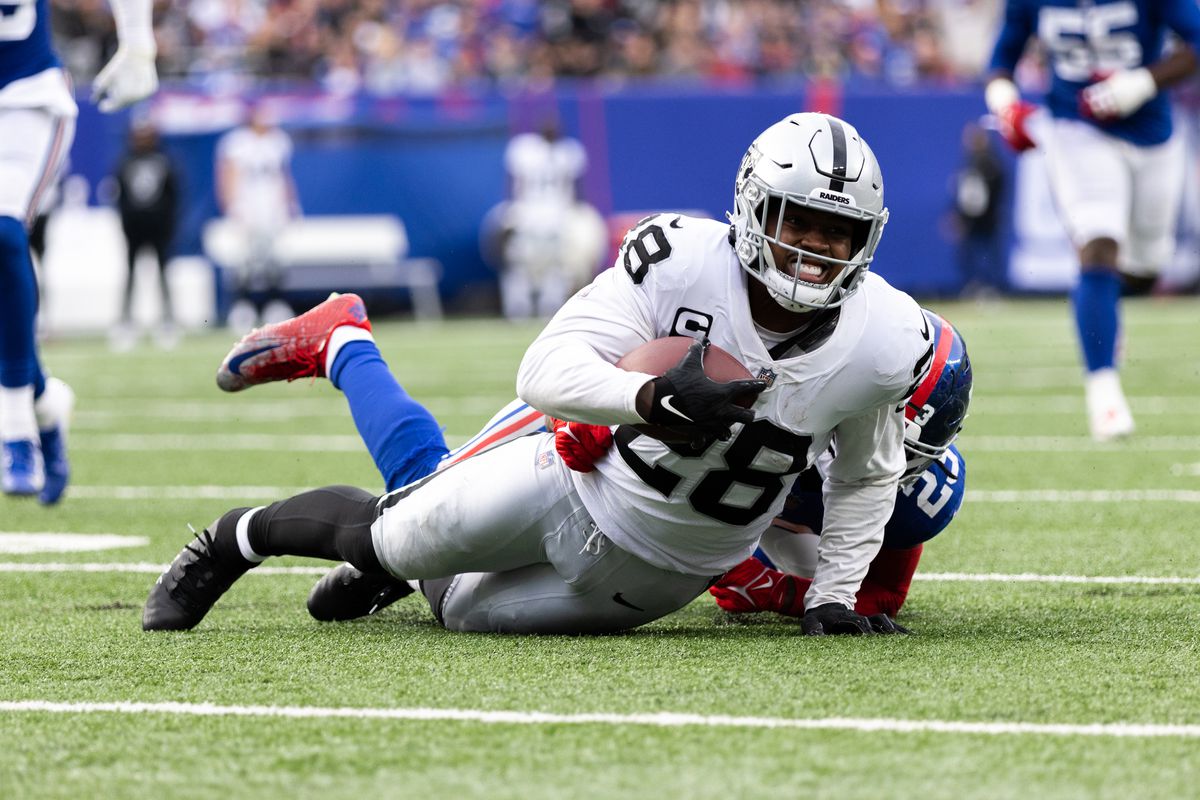 Josh Jacobs #28 of the Las Vegas Raiders is tackled by Logan Ryan #23 of the New York Giants during a game at MetLife Stadium on November 7, 2021 in East Rutherford, New Jersey.