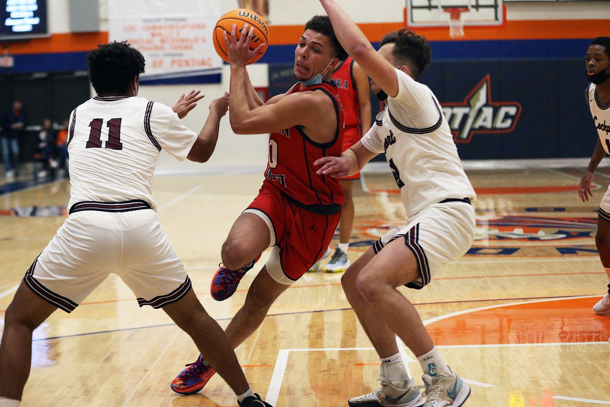 West Aurora’s Isaiah Siler (20) tries to split Lockport defenders Anthony Munson (11) and Niko Vassilakis (21) in the opening game of the Pontiac Holiday Tournament.