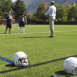 Kicker Vance "Moose" Bingham, third from left, tosses the ball to a coach during a BYU football practice at BYU's practice fields Thursday, Aug. 14, 2014.