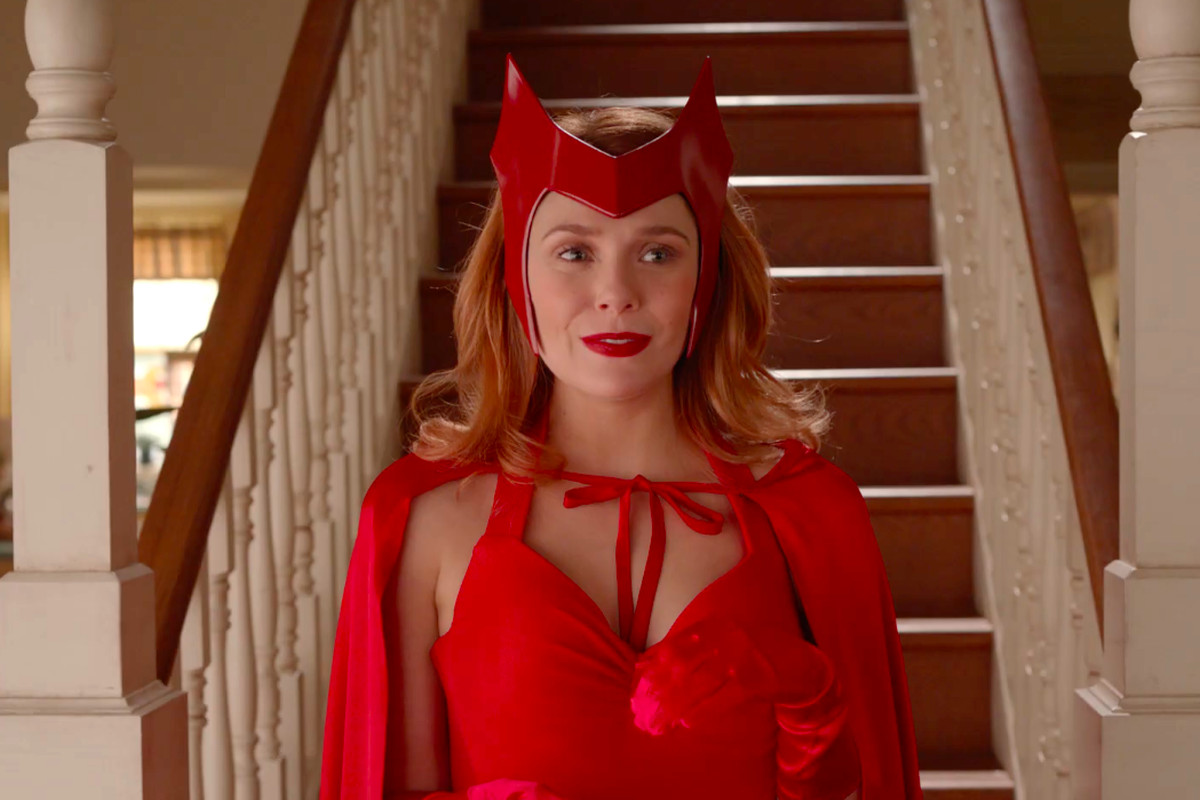 Elizabeth Olsen descends a staircase as Scarlet Witch in her classic costume, complete with gloves, cape, and hairpiece, in a clip from teaser for WandaVision.