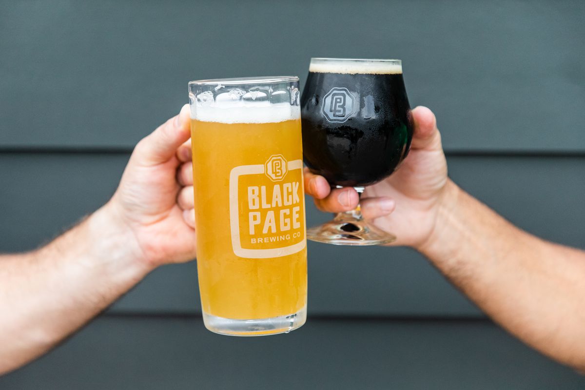 Two people clinking glasses of Black Page Brewing beer together.