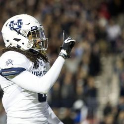 Utah State cornerback Wesley Bailey (8) signals to Brigham Young fans after making a play during an NCAA college football game in Provo on Saturday, Nov. 26, 2016.
