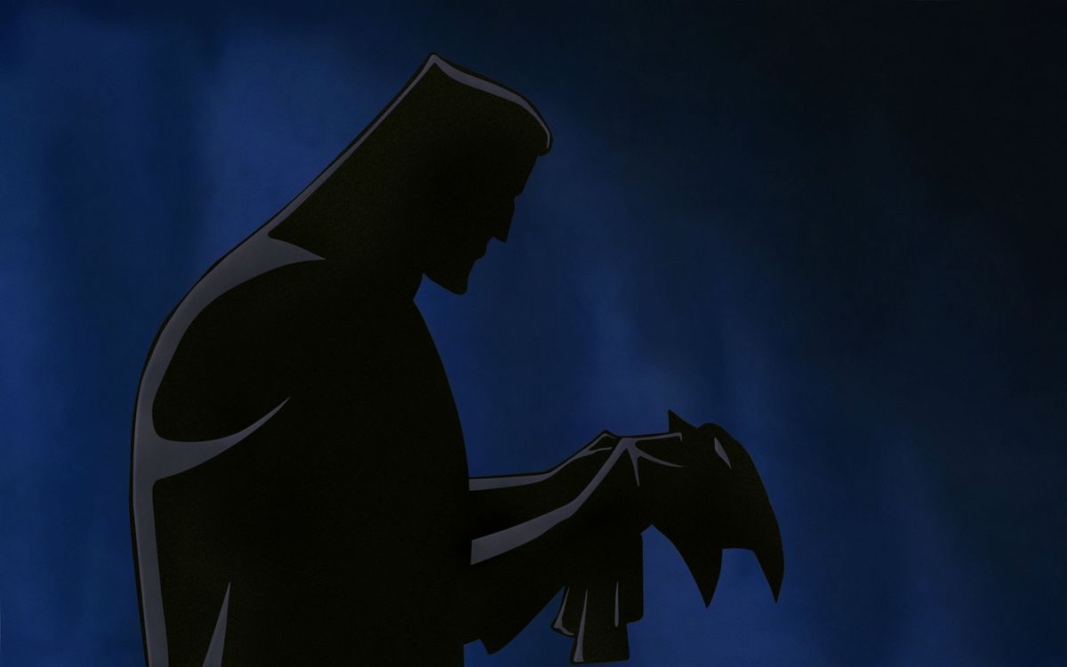 a man looks at a mask in batman: mask of the phantasm