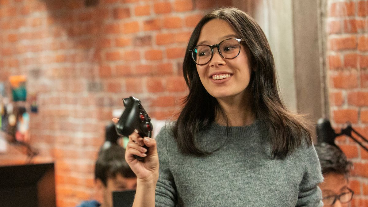 Poppy (Charlotte Nicdao) holds an Xbox controller in the Mythic Quest office