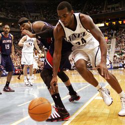 Paul Milsap of the Utah Jazz (right) and Josh Smith of the Atlanta Hawks chase a loose ball.