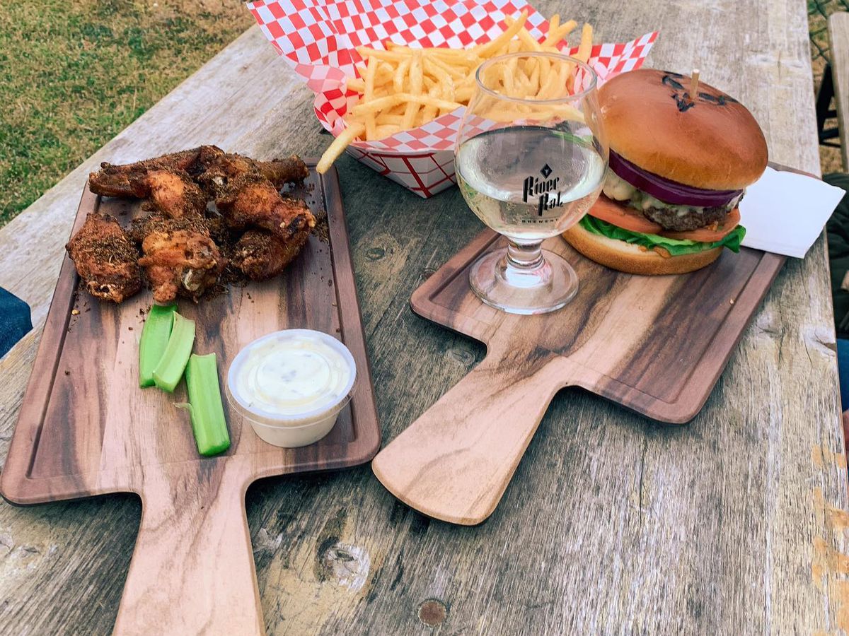 Wings and a burger on wooden cutting boards. 