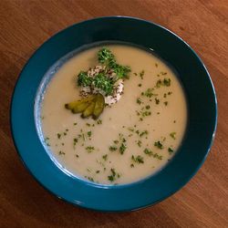Winterfest Sauerkraut Soup is garnished with sour cream, caraway seeds, parsley and pickles.
