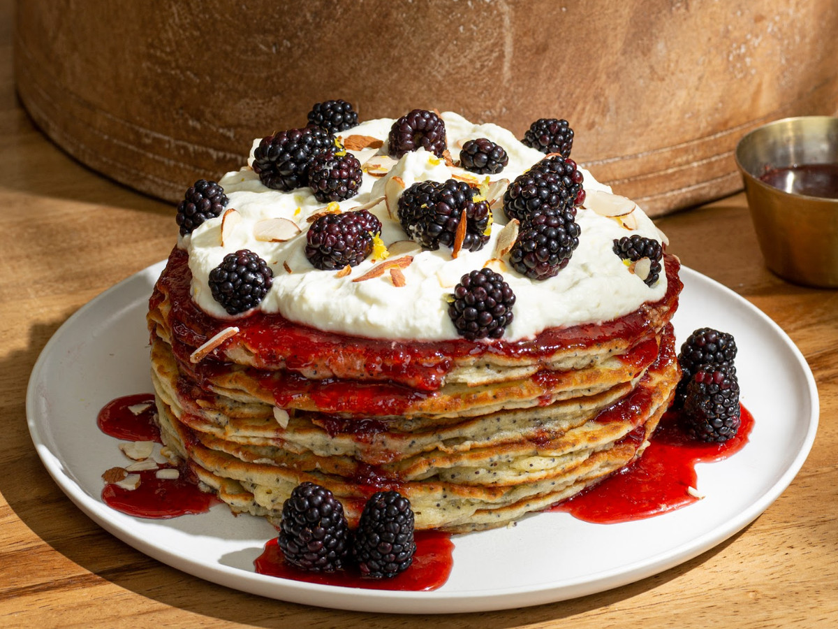 A stack of poppy seed pancakes with cream and blackberries from Casa Madera.