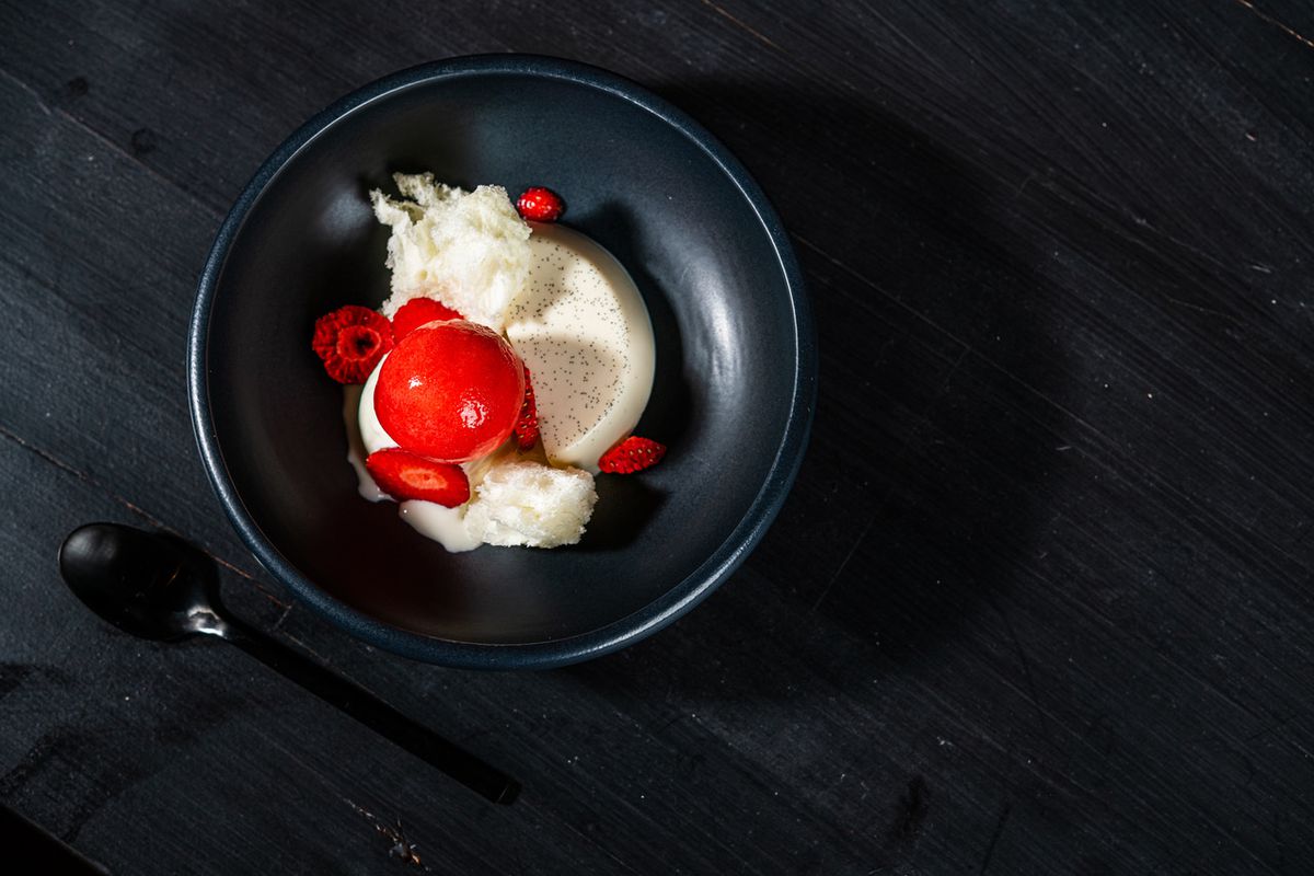 A scoop of bright red strawberry sorbet complements vanilla bean-studded panna cotta and white queso fresco ice cream at Maïz64.