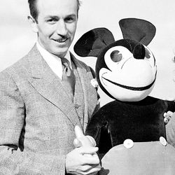 Walt Disney poses with one of his creations, Mickey Mouse, on the roof of Grosvenor House in London, June. 12, 1935.