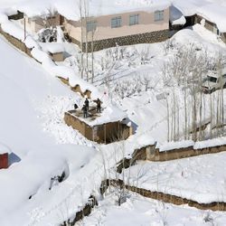 Afghans clean snow from a rooftop after an avalanche in the Paryan district of Panjshir province, north of Kabul, Afghanistan, Friday, Feb. 27, 2015. The death toll from severe weather that caused avalanches and flooding across much of Afghanistan has jumped to more than 200 people, and the number is expected to climb with cold weather and difficult conditions hampering rescue efforts, relief workers and U.N. officials said Friday. 